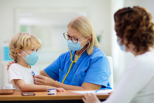 Doctor Examining Sick Child In Face Mask