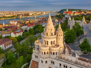 Fototapeta premium Budapest, Hungary - Aerial view of the famous Fisherman's Bastion at sunset with Szechenyi Chain Bridge, Elisabeth Bridge and Buda Castle Royal Palace at background on a sunny summer afternoon