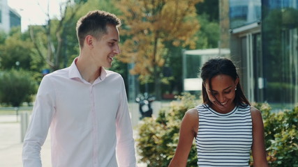 Obraz premium Mixed-race family of two holding hands, walking and talking to each other in one summer day. Happiness concept.