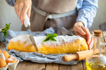 Apple strudel from the oven. Mint strudel.The cook makes the cake.Housewife is preparing an apple pie.Mom prepares dessert.Vienna apple strudel. Sliced ​​piece of cake.Mistress cuts homemade dessert 