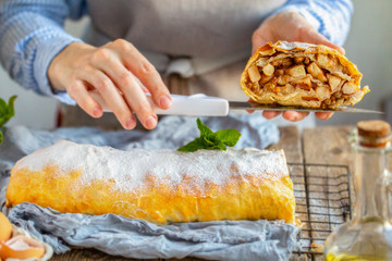 Apple strudel from the oven. Mint strudel.The cook makes the cake.Housewife is preparing an apple pie.Mom prepares dessert.Vienna apple strudel. Sliced ​​piece of cake.Mistress cuts homemade dessert 