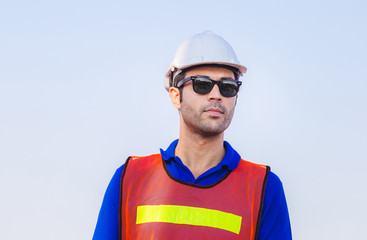 Cheerful factory worker man in hard hat smiling and looking at sky with joy, Happiness concept