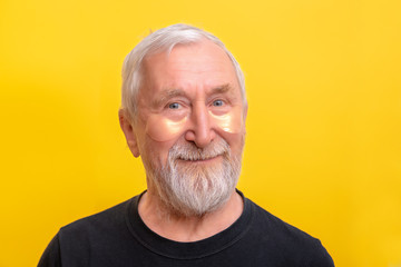 Senior man with eye patch gold and snail showed to it copy space