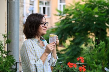 Fototapeta premium Mature woman drinking water with lemon. Natural antioxidant, diet drink