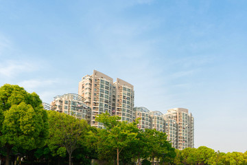 Fototapeta premium The city park under the blue sky. There is upscale residential quarter in the distant.