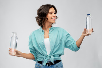 people concept - portrait of happy smiling young woman in turquoise shirt comparing water in...