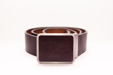 Close-up new classic men's brown leather belt with metal rectangular buckle on a white background. 