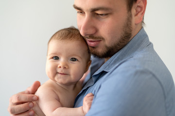 Young father holding his newborn baby daughter