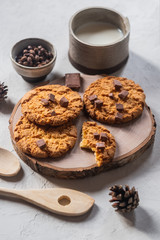 traditional freshly baked round cookies with raisins on a plate and a glass of milk on a gray background.