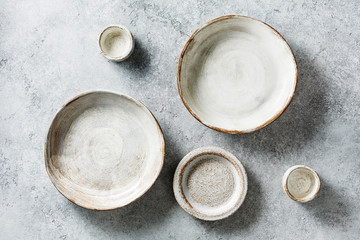 Tableware set of ceramic on a stone dark background. Top view.