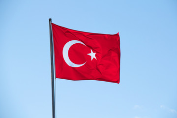 Turkish flag waving in sky.