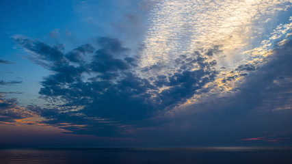 Naklejka na ściany i meble Beautiful scenic sunset over water. Baltic sea. Cloudy weather. Soft focus of sea.