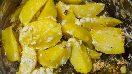 Appetizing stewed potatoes on dark background closeup