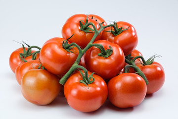 Eine Menge, ein Haufen frischer roter saftiger Rispentomaten / Tomate