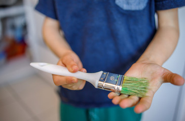 Young boy holding painting brush