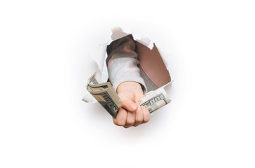 A small child hand appears in the hole in torn white paper and squeezes two hundred-dollar bills.The concept of alimony poverty, benefits, scholarships, and stinginess.Background for copy space