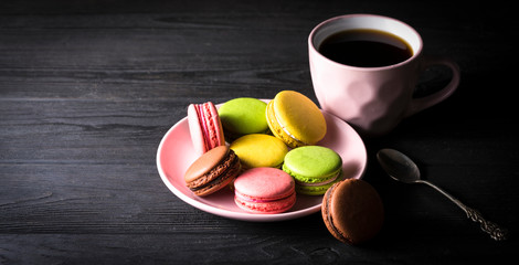 macaroons and coffee on black background