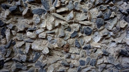 Old gray small stones on the wall