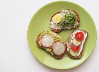 Sandwiches with healthy vegetables and micro greens on colorful background.