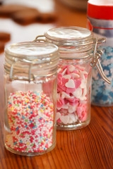 Different sugar sprinkles in small jars of glass