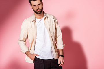 Fashionable young man posing in summer clothes on pink background