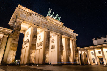 Obraz premium Low angle view of the Brandenburg Gate in Berlin at night with stars in sky. Germany