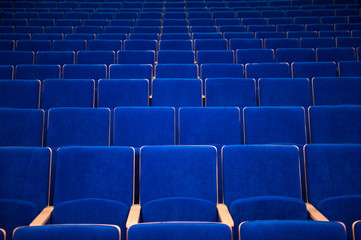 blue chairs in theatre with beige elbow-rest