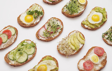 Sandwiches with healthy vegetables and micro greens on colorful background.