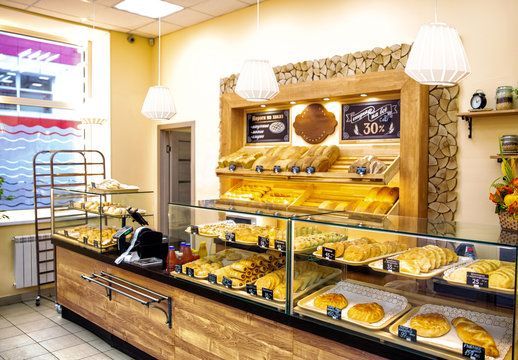Baked baguettes and pies on showcase in bakery shop. Inscriptions in russian with the name baking