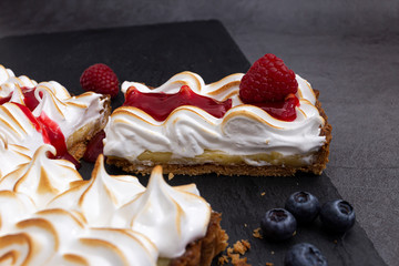 Flat lay close-up with home-cooked meringue cake and berry coulis jam 