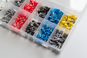 Tips of different sizes and colors for crimping stranded electrical wires. Wire tips in the box.