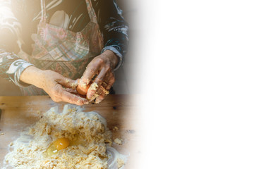 Old woman hands preparing dough with flour and eggs. Free white space for text on the right.