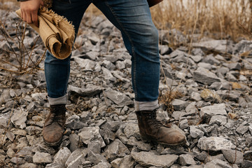 legs of a man in boots on stones