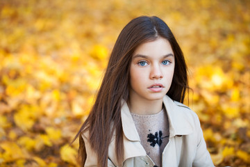 Happy young little girl in beige coat