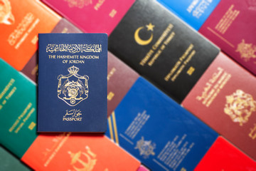 Passport of the Hashemite Kingdom of Jordan on a blurred background various passports of the world.