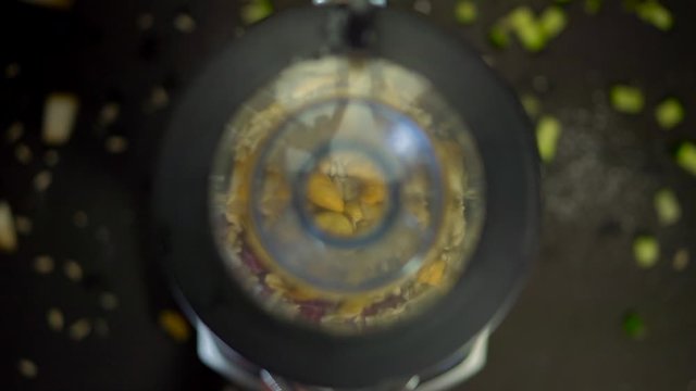 Mix food under the lid of a blender with cucumber, cashews, seeds, beets, pink food and smoothies.The process of making smoothies in a mixer, berry puree, Smoothie Bowl. Proper nutrition in the mixer