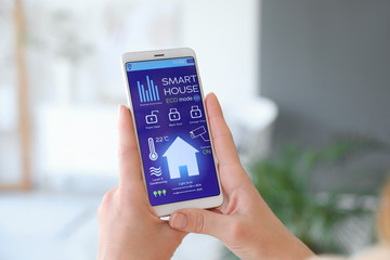 Woman using application of smart home automation
