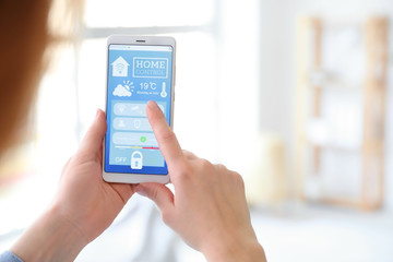 Woman using application of smart home automation