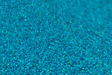 Fototapeta na wymiar Blue and transparent pool water, moved by the breeze of the wind, in spring
