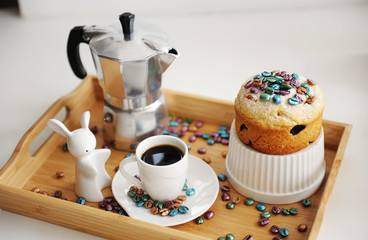 Easter still life. Coffee and cake. Espresso maker moka pot. White dishes, ceramic easter bunny. Colored coffee beans