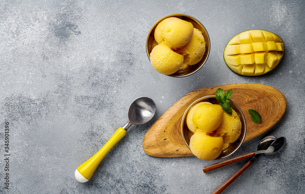 Fototapete mango ice cream on gray concrete background. copy space. top view of mango slices and ice cream in b