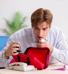 Man with first aid kit in the office