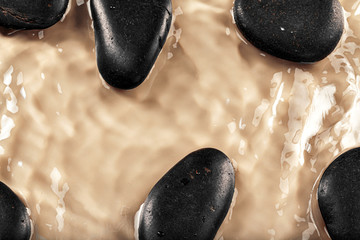 Massage spa stones close up in wavy water background