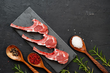 Raw fresh lamb ribs on dark background, close up.
