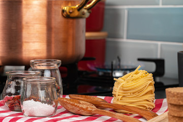 Dry spaghetti on a kitchen counter with cooking utensils close up