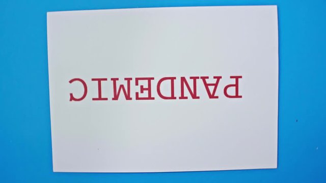 Top view of spinning card with pandemic lettering on blue background
