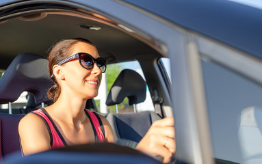 Girl drives a car on a sunny day.