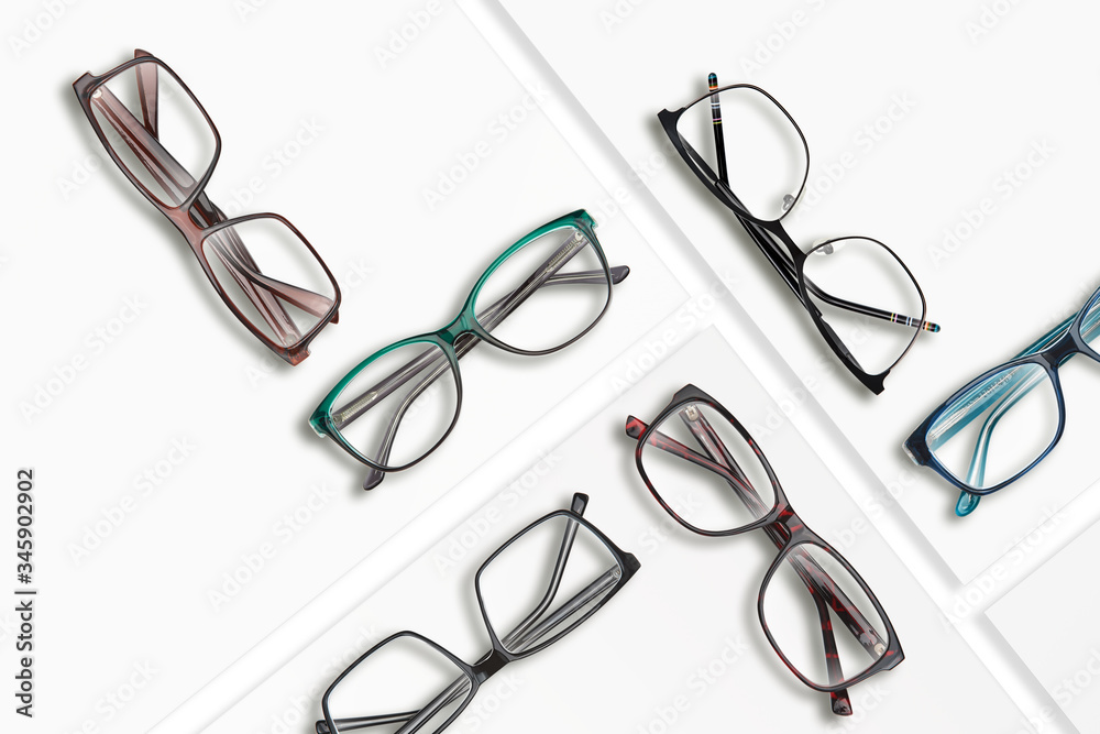 Poster composition of many different classic style glasses on white square stands.