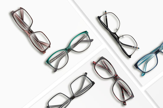 Composition of many different classic style glasses on white square stands.