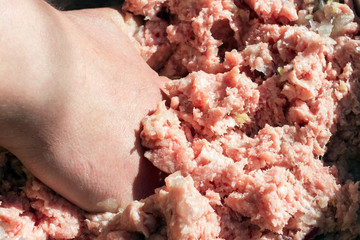 a person mix the minced meat with his hand while cooking the dish. Non-vegetarian menu and unhealthy food